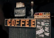 Coffee shop display with vintage decor, menu, and various bottled drinks.