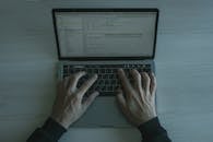 Close-up view of a programmer coding on a laptop, showcasing modern software development.